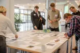 Teilnehmende arbeiten an einer Themenstation, bei welcher sie Fotos auswählen und beschriften