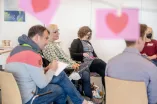 Teilnehmende arbeiten an einer Themenstation und schreiben auf Karten, warum sie sich für die Ruhr-Universität Bochum entschieden haben