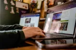Eine Person arbeitet am Laptop an der Webseite der RUB.