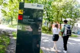 Wegweiser und Weg, auf dem zwei Personen gehen