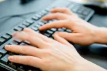 Das Foto zeigt eine Tastatur, auf der zwei Hände tippen