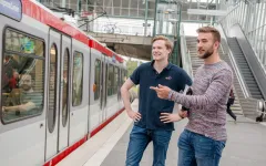 Foto: Zwei Studenten erwarten die gerade einfahrende U35 Linie. 