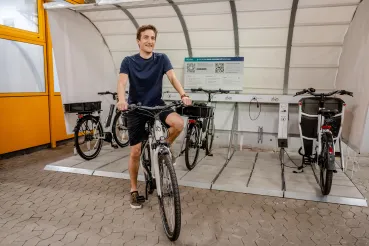 Foto: Männliche Person testet eines der E-Bikes für Dienstgänge auf dem Campus der Ruhr-Universität Bochum