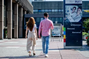 Zwei Personen gehen an der Verwaltung vorbei