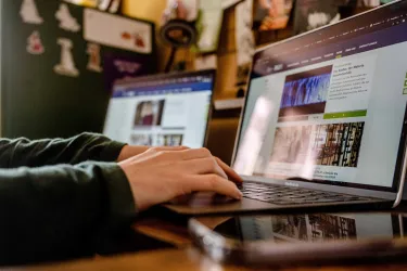 Eine Person arbeitet am Laptop an der Webseite der RUB.