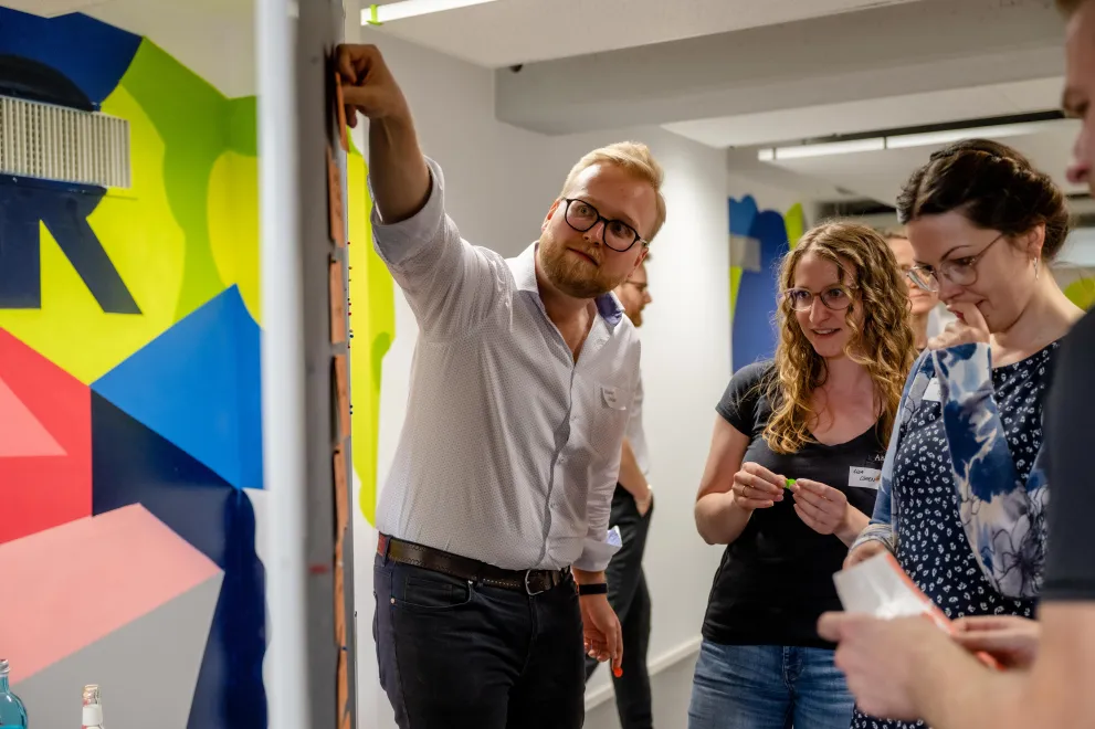 Teilnehmende des Workshops sammeln ihre Ideen an einer Pinnwand