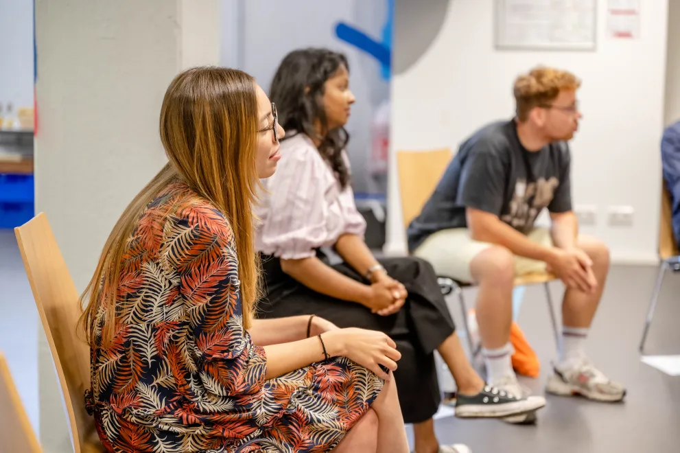 Die Teilnehmenden sitzen in einem Stuhlkreis und tauschen sich aus