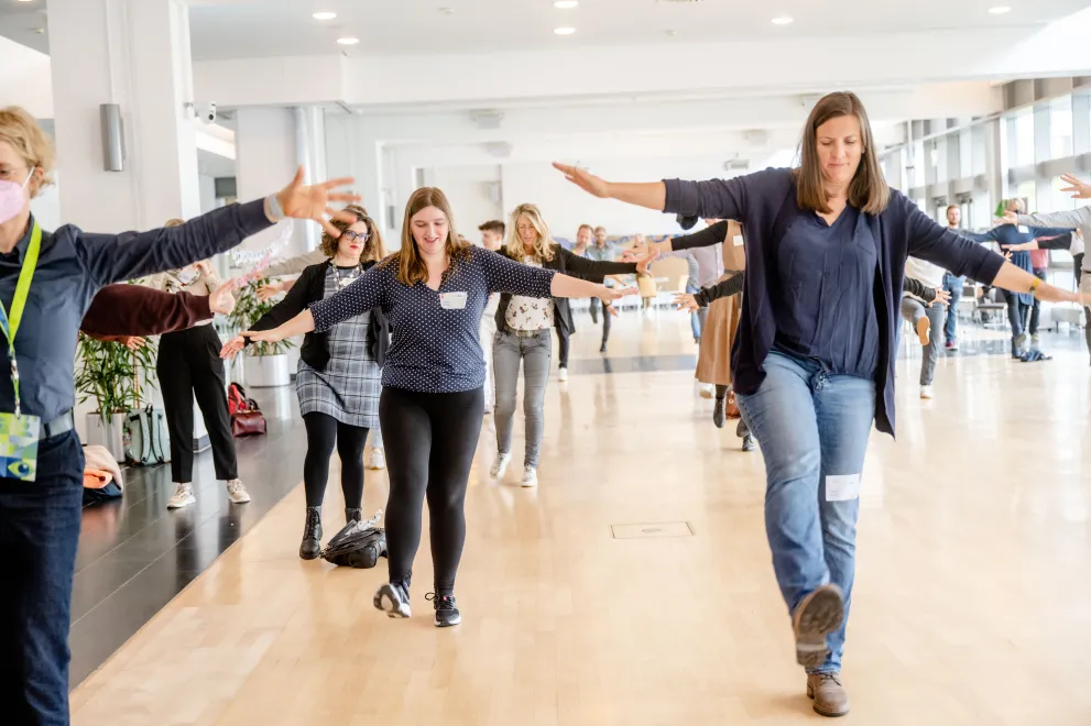 Teilnehmende machen gemeinsam eine Sporteinheit, die vom Hochschulsport-Team geleitet wird.