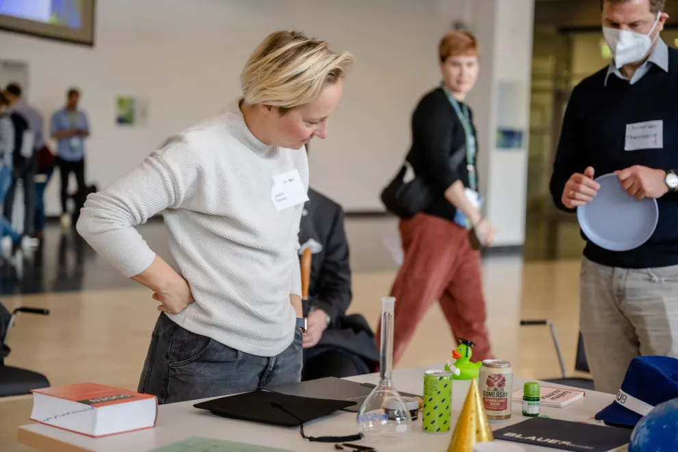 Teilnehmende bearbeiten eine Themenstation, an der sie Gegenstände heraussuchen, die sie mit der RUB verbinden.