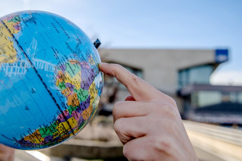 Ein Globus auf dem Campus der RUB. Ein Finger zeigt auf Deutschland.