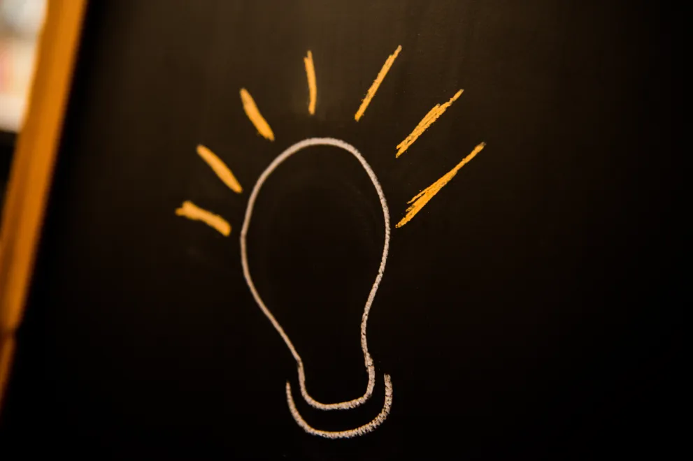 Eine Glühbirne ist auf eine Tafel gezeichnet.
