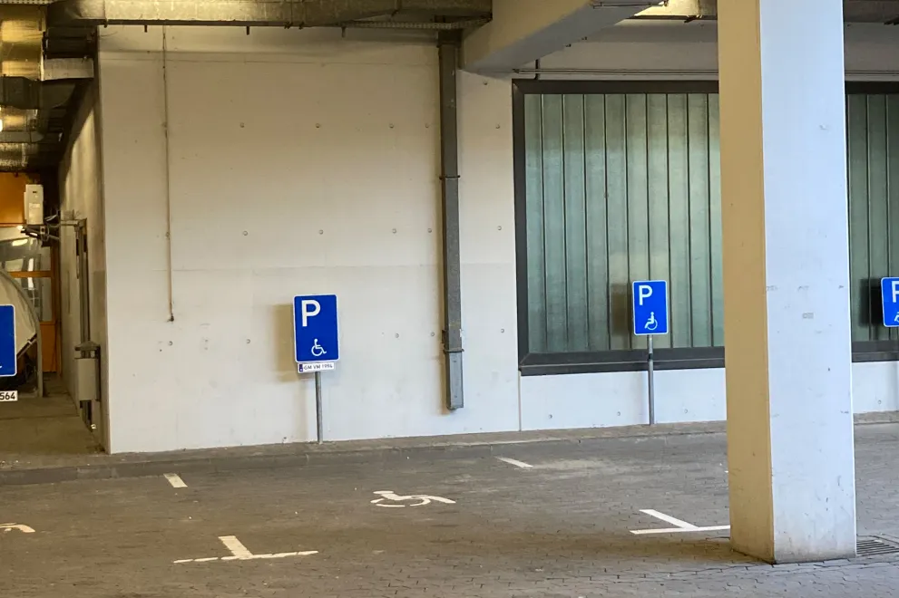 Image: Signage for the barrier-free parking spaces in the bus station below the university administration: The personal parking spaces can be identified by the individual vehicle registration number.