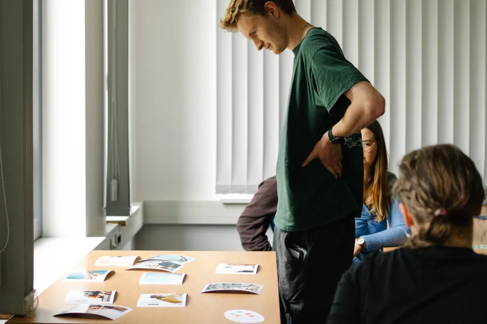 Foto: Eine Person schaut auf einen Tisch mit Fotos.